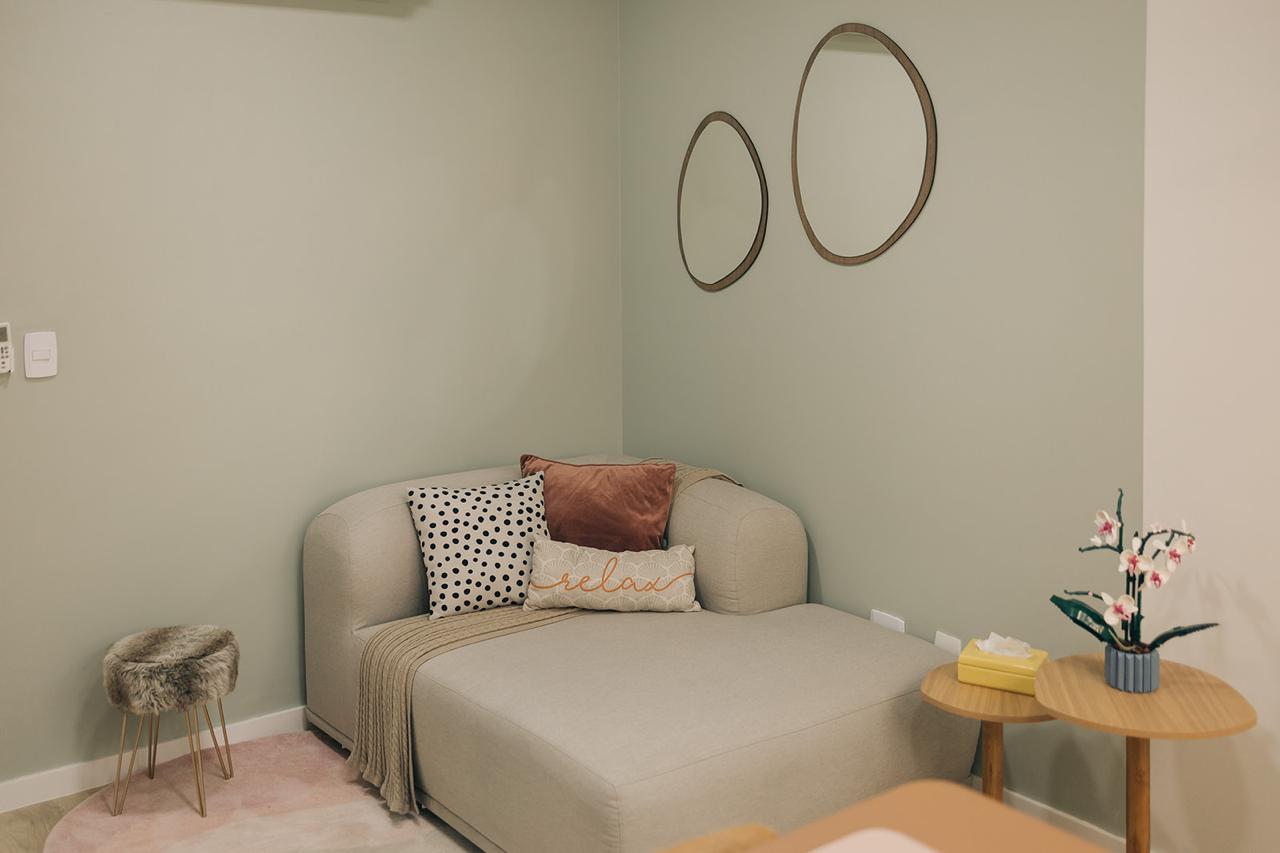 Sala de acolhimento com sofá e decoração delicada